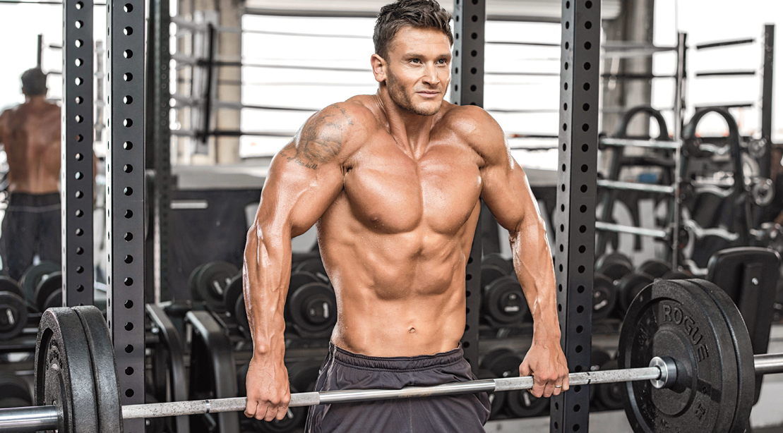 Muscular fit man working out with neck exercises and his shoulders with a kirk shrug exercise