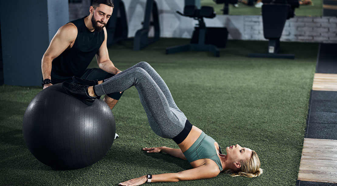 Fit female working out her hamstrings with the stability ball hamstring curl exercise