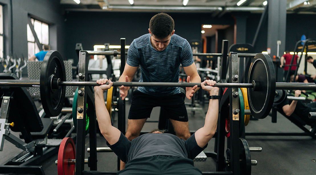 Fitness Trainer sharing his bench press tips with his clients