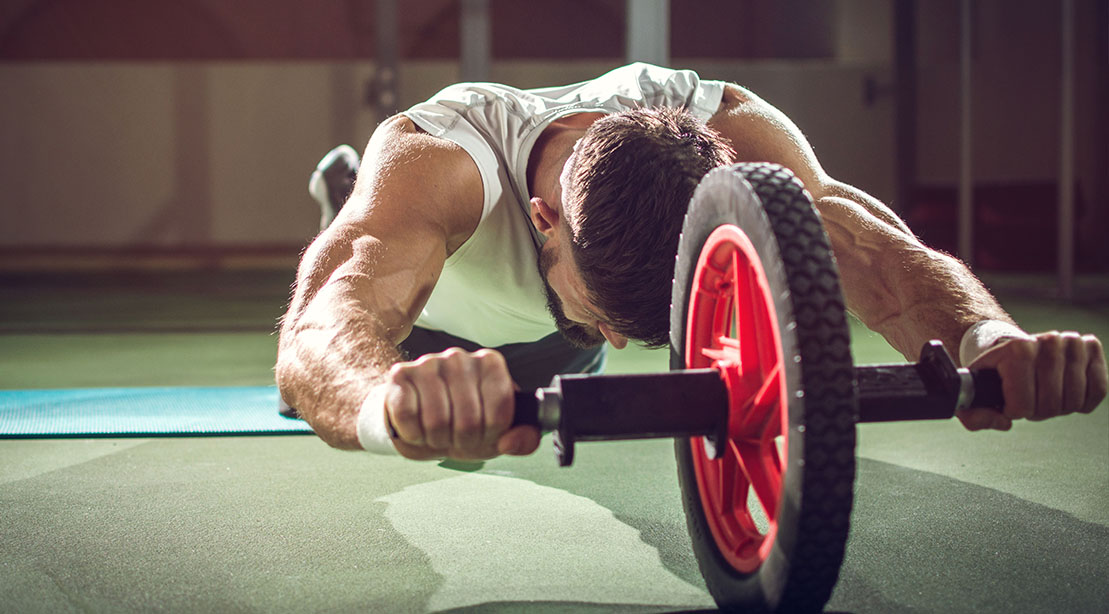 Man working out his core muscles witht he ab rollout exercise