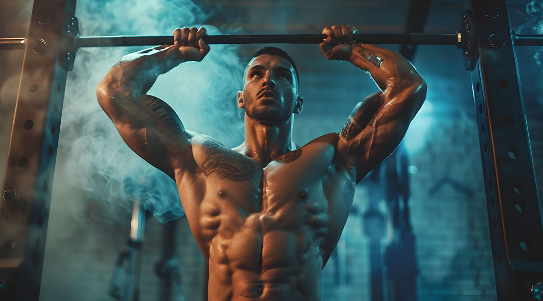 Muscular fit man performing a scrape the rack press exercise at the gym