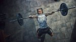 Young fit man performing a barbell bench press exercise while incorporating a cluster drop sets training method